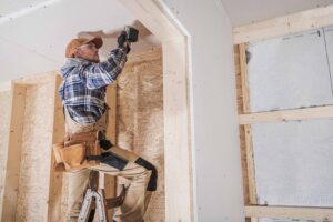 General home contractor working on the walls of a new home